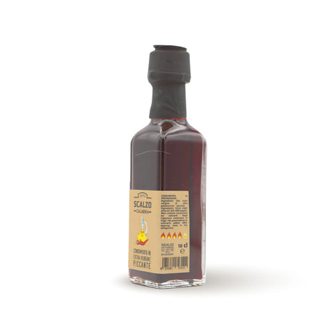 Condimento al Peperoncino - Bottiglia di olio extravergine di oliva rosso intenso con peperoncino, ideale per condire piatti gourmet.