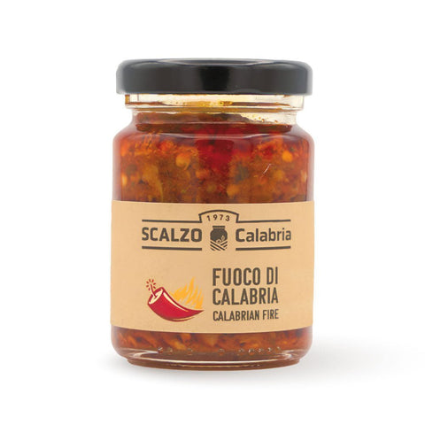 Vaso frontale da 100 grammi di Fuoco di Calabria Scalzo Calabria, una salsa piccante a base di peperoncini calabresi e altri ingredienti locali, conservata in olio extra vergine d'oliva